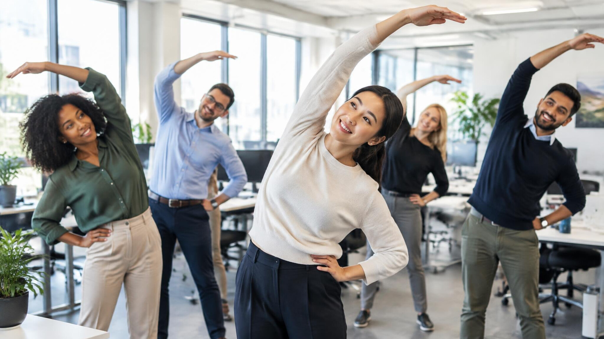 Group of colleagues doing a stretching exercise in the office